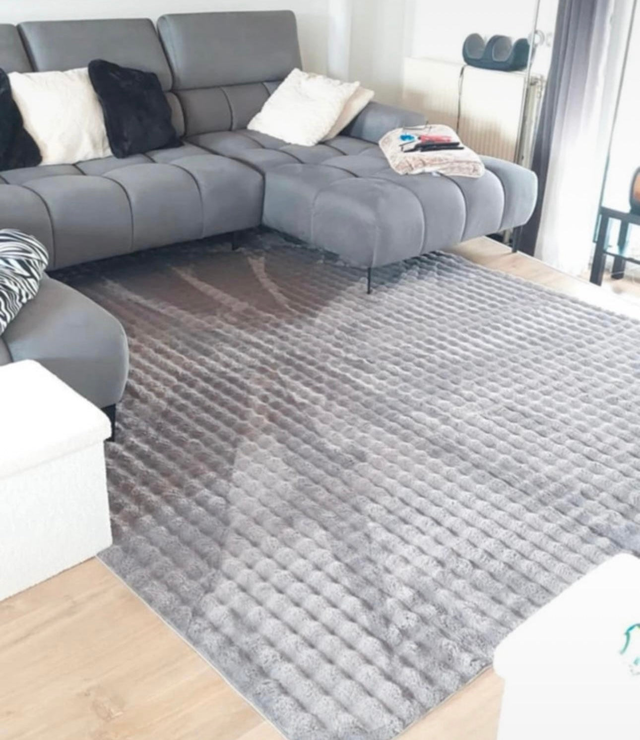 Tapis Bubble anthracite à relief bulles 3D installé dans un salon moderne et chic.