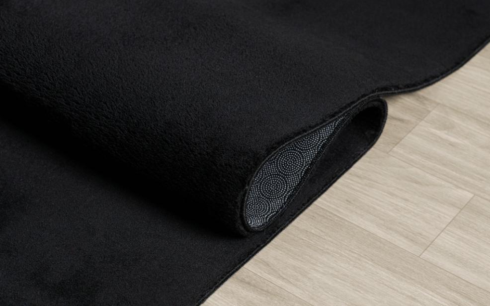 Tapis LOFT noir plié de manière compacte pour un passage en machine à laver, prouvant que le noir reste facile à entretenir et à garder propre.