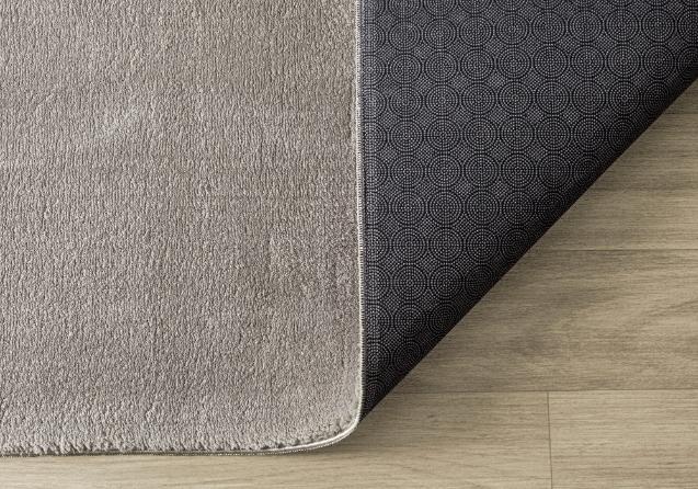 Tapis LOFT taupe souple et plié pour un lavage en machine facile, garantissant une hygiène parfaite au quotidien.