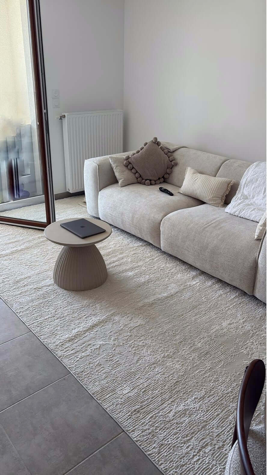 Rendu client du tapis SIGNO 05 : Zoom sur les reflets lumineux de la fibre crème et le relief des lignes en lumière naturelle.