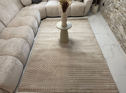 Tapis beige ELIO 51 avec motifs d'arches en relief dans un salon au style moderne organique et épuré.