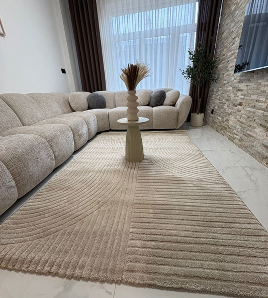 Tapis beige ELIO 51 avec motifs d'arches en relief dans un salon au style moderne organique et épuré.