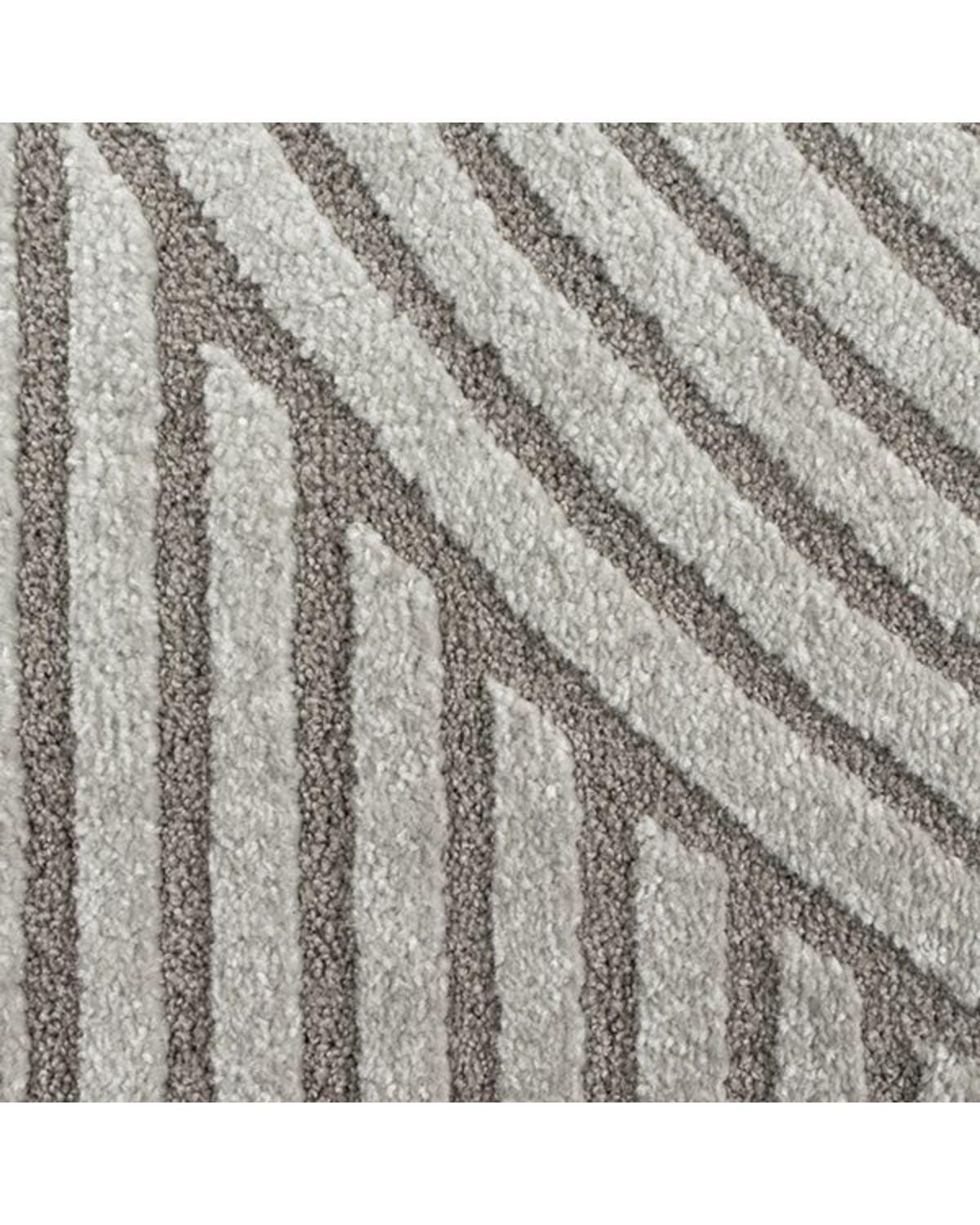 Gros plan sur les motifs en arc de cercle du tapis ELIO 51 gris, montrant le relief sculpté et la densité des fibres.