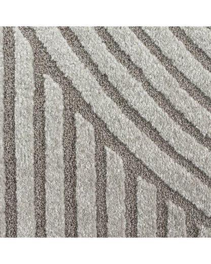 Gros plan sur les motifs en arc de cercle du tapis ELIO 51 gris, montrant le relief sculpté et la densité des fibres.