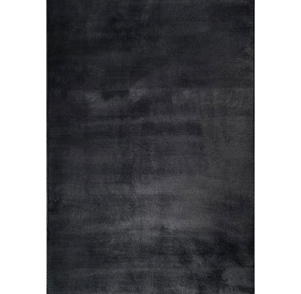 Zoom sur la fibre soyeuse du tapis noir FOCUS, texture ultra-douce et reflets profonds.