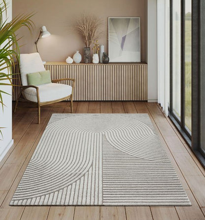 Tapis gris ELIO 51 avec motifs d'arches en relief dans un salon au style moderne organique et épuré.
