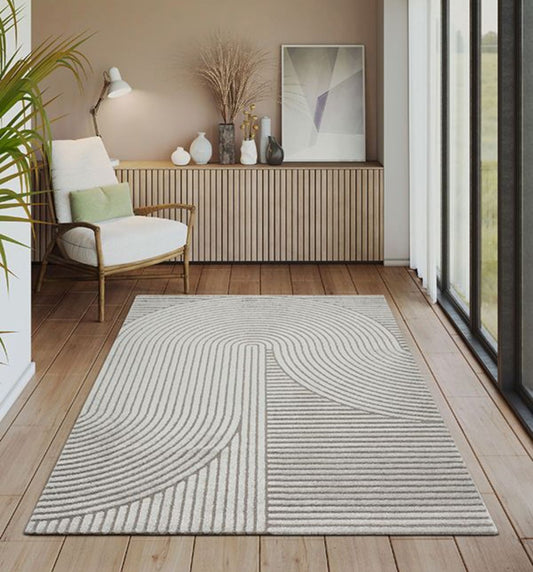 Tapis gris ELIO 51 avec motifs d'arches en relief dans un salon au style moderne organique et épuré.