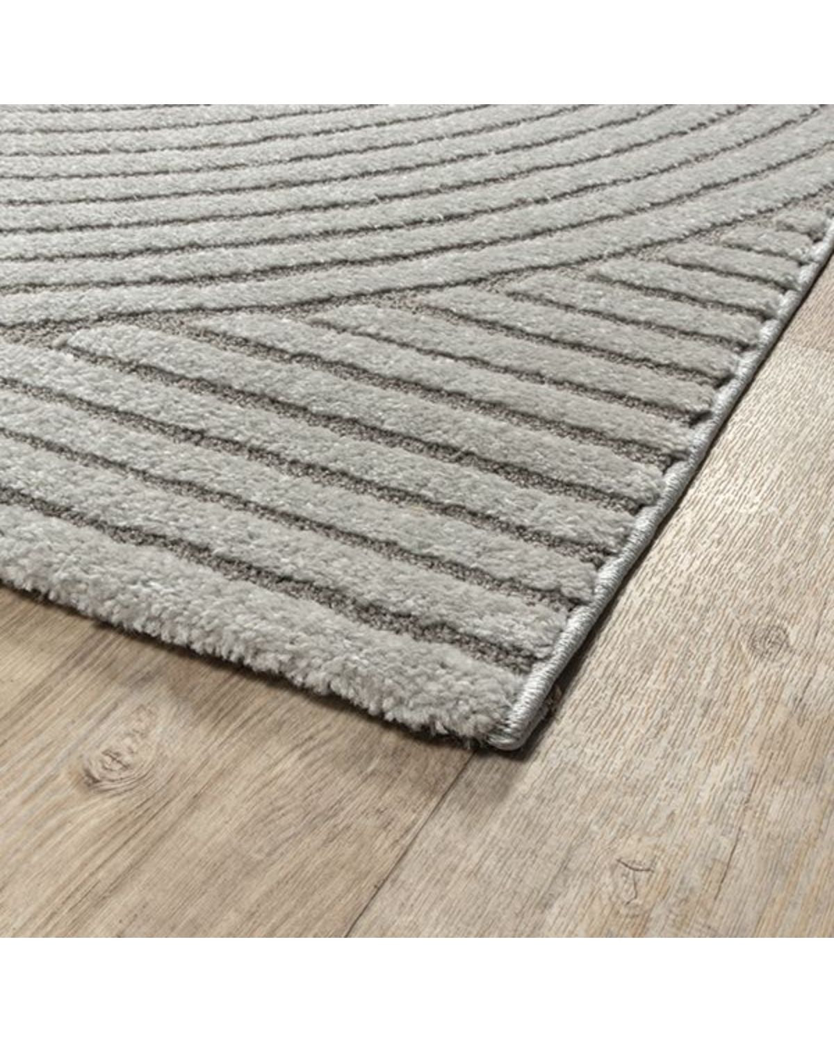 Détail de la finition sur le bord du tapis ELIO 51, mettant en avant la texture douce et le tissage haut de gamme.
