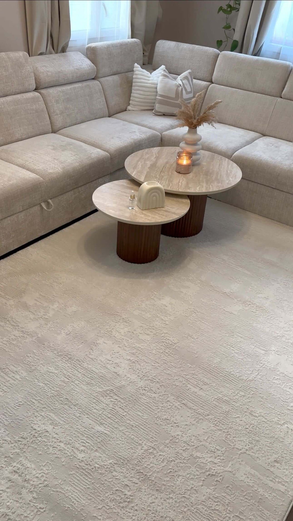 Tapis minimaliste SIGNO 05 crème avec motif de lignes en relief dans un salon lumineux au design contemporain.