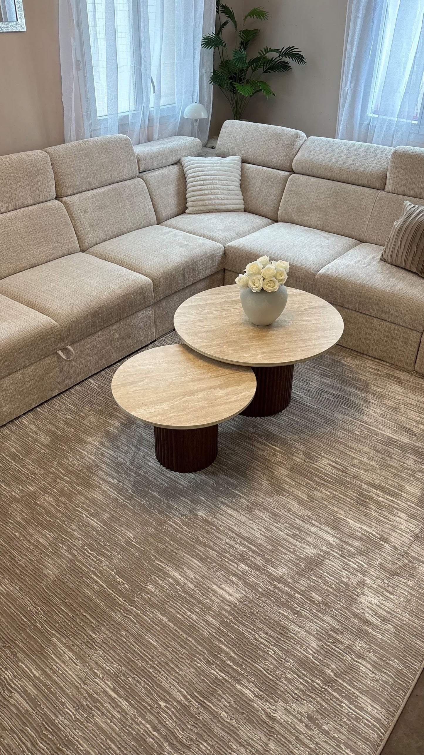 Tapis doux à effet 3D installé sous un canapé d'angle beige, créant une ambiance cocooning et élégante.