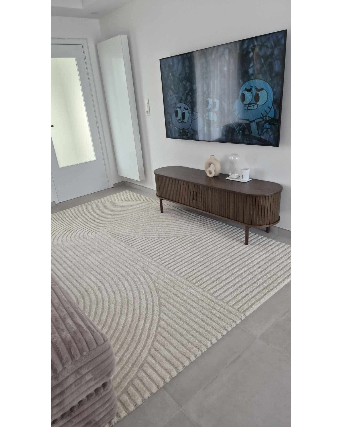 Tapis crème ELIO 51 avec motifs d'arches en relief dans un salon au style moderne organique et épuré.