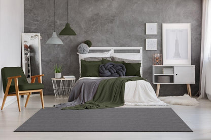 Tapis LOFT anthracite installé dans une chambre à coucher moderne, créant une ambiance douce et chaleureuse pour une sortie de lit moelleuse.