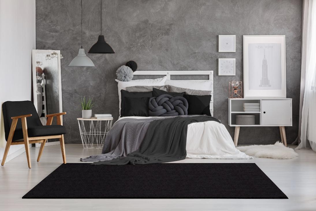 Tapis LOFT noir dans une chambre moderne, apportant une atmosphère feutrée, luxueuse et ultra-confortable.