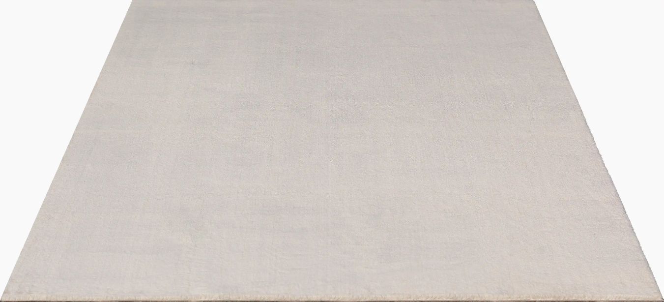 Tapis rectangulaire LOFT beige présenté sur fond blanc uni, montrant la couleur blanc cassé pure et la texture dense à poils hauts.