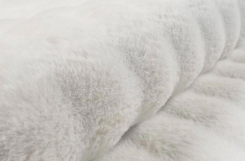 Détail en gros plan sur le tissage du tapis Bubble crème, montrant le contraste entre le fond plat et le relief sculpté et doux des bulles 3D.