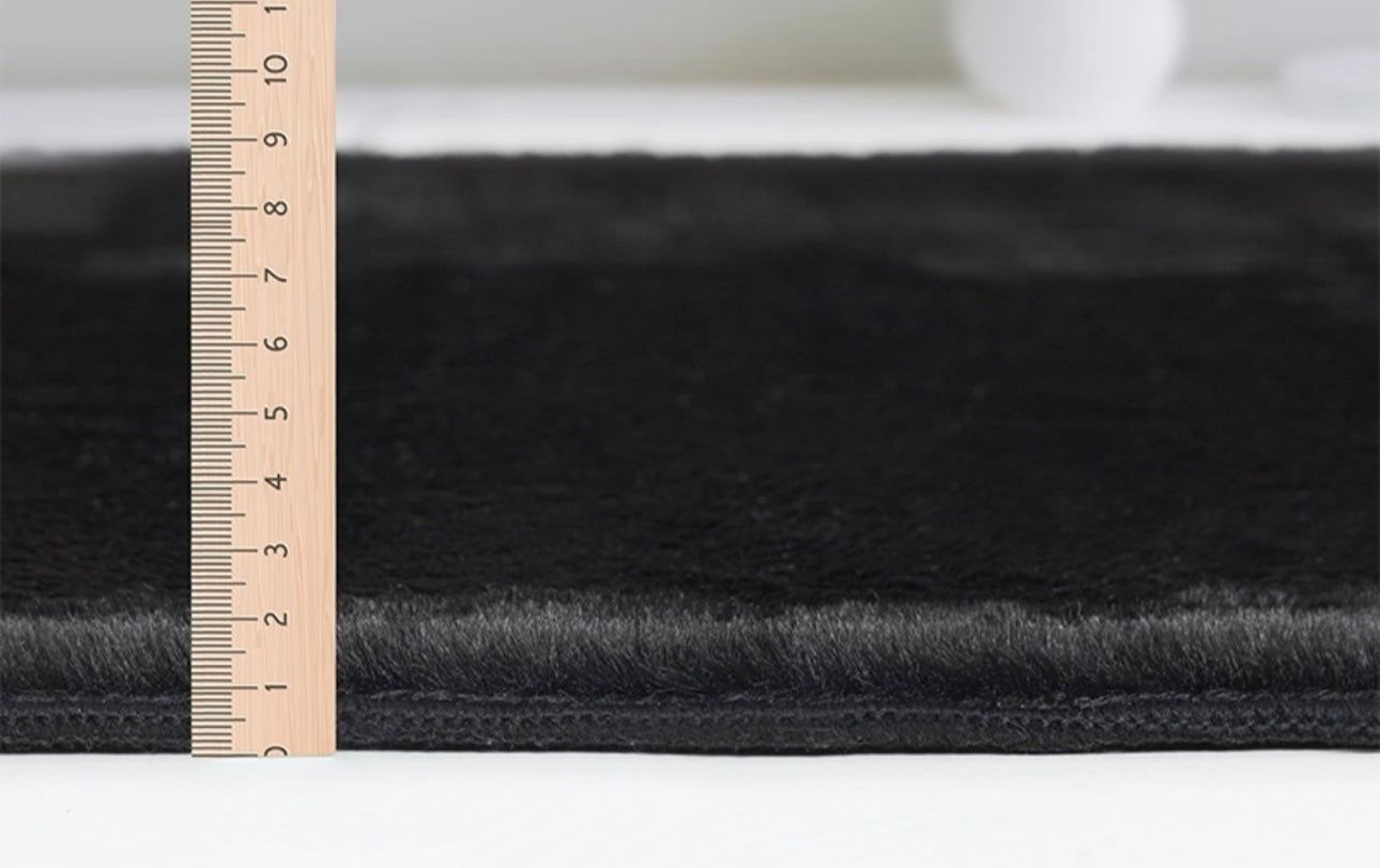 Détail du tissage dense et moelleux du tapis FOCUS noir, confort premium et entretien facile.