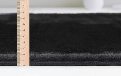 Détail du tissage dense et moelleux du tapis FOCUS noir, confort premium et entretien facile.