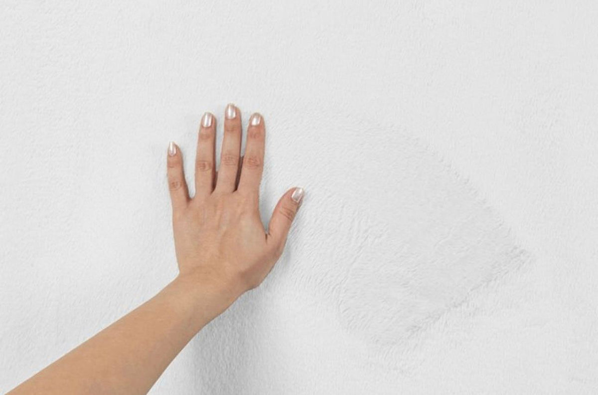 Zoom sur la texture ultra-douce du tapis FOCUS blanc, sensation poils de soie et confort moelleux.