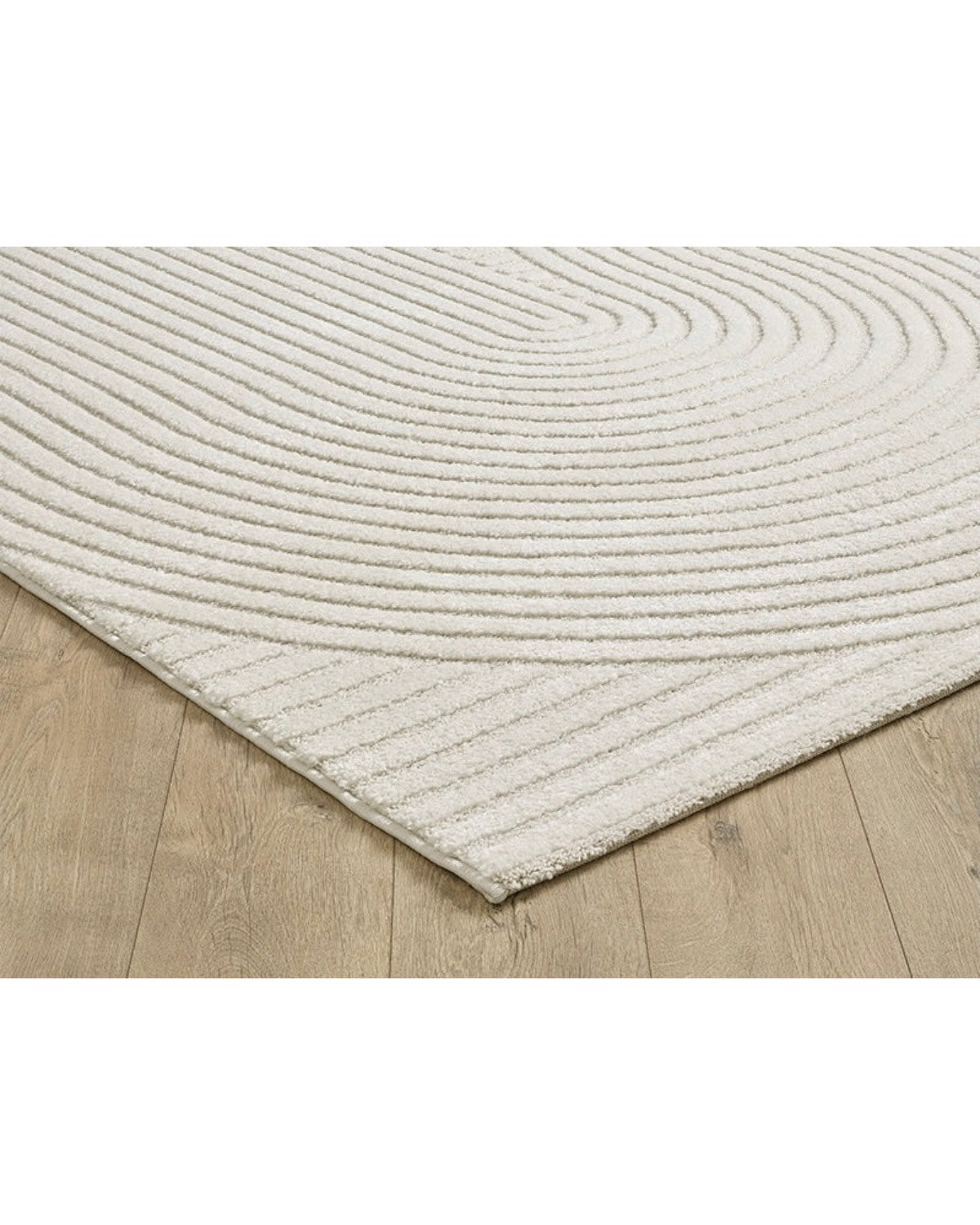 Gros plan sur les motifs en arc de cercle du tapis ELIO 51 crème, montrant le relief sculpté et la densité des fibres.