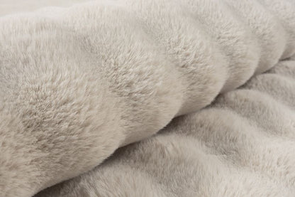 Détail en gros plan sur le tissage du tapis Bubble beige, montrant le contraste entre le fond plat et le relief sculpté et doux des bulles 3D.