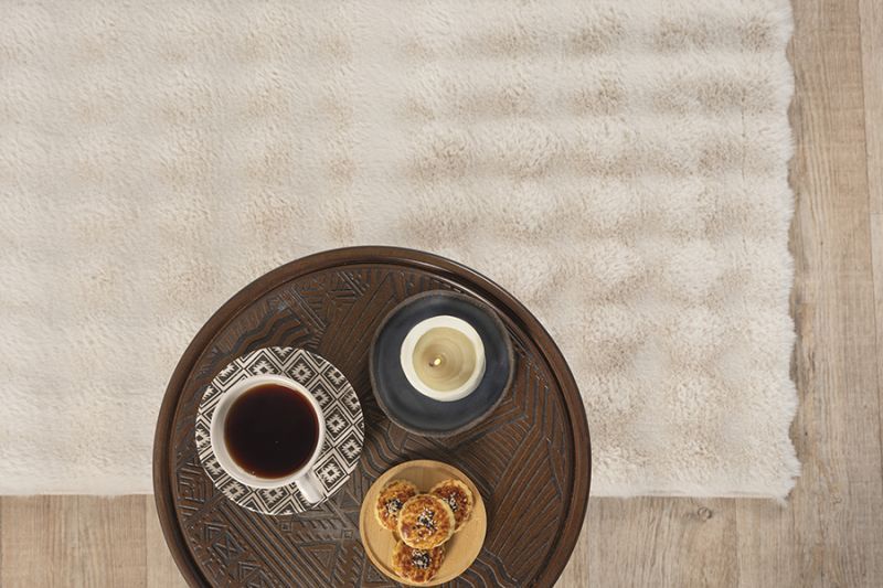 Vue du coin du tapis Bubble beige illustrant sa grande souplesse et son dossier antidérapant, idéal pour un entretien facile en machine à laver.