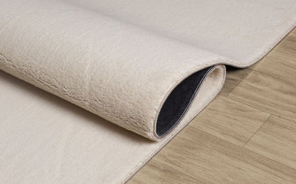 Démonstration du tapis LOFT beige plié pour le lavage en machine, prouvant qu'une couleur claire reste facile à entretenir.