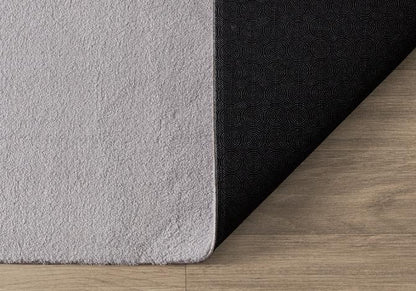 Tapis LOFT gris clair souple et plié pour un lavage en machine facile, garantissant une hygiène parfaite au quotidien.