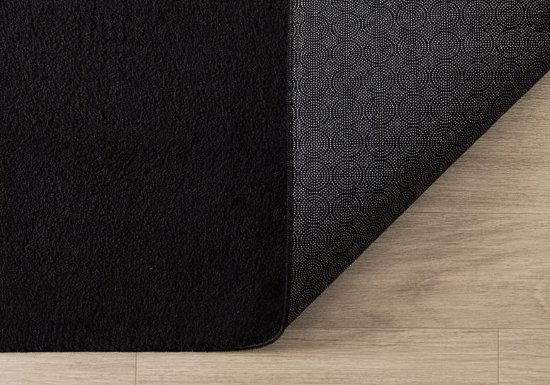 Tapis LOFT noir plié de manière compacte pour un passage en machine à laver, prouvant que le noir reste facile à entretenir et à garder propre.
